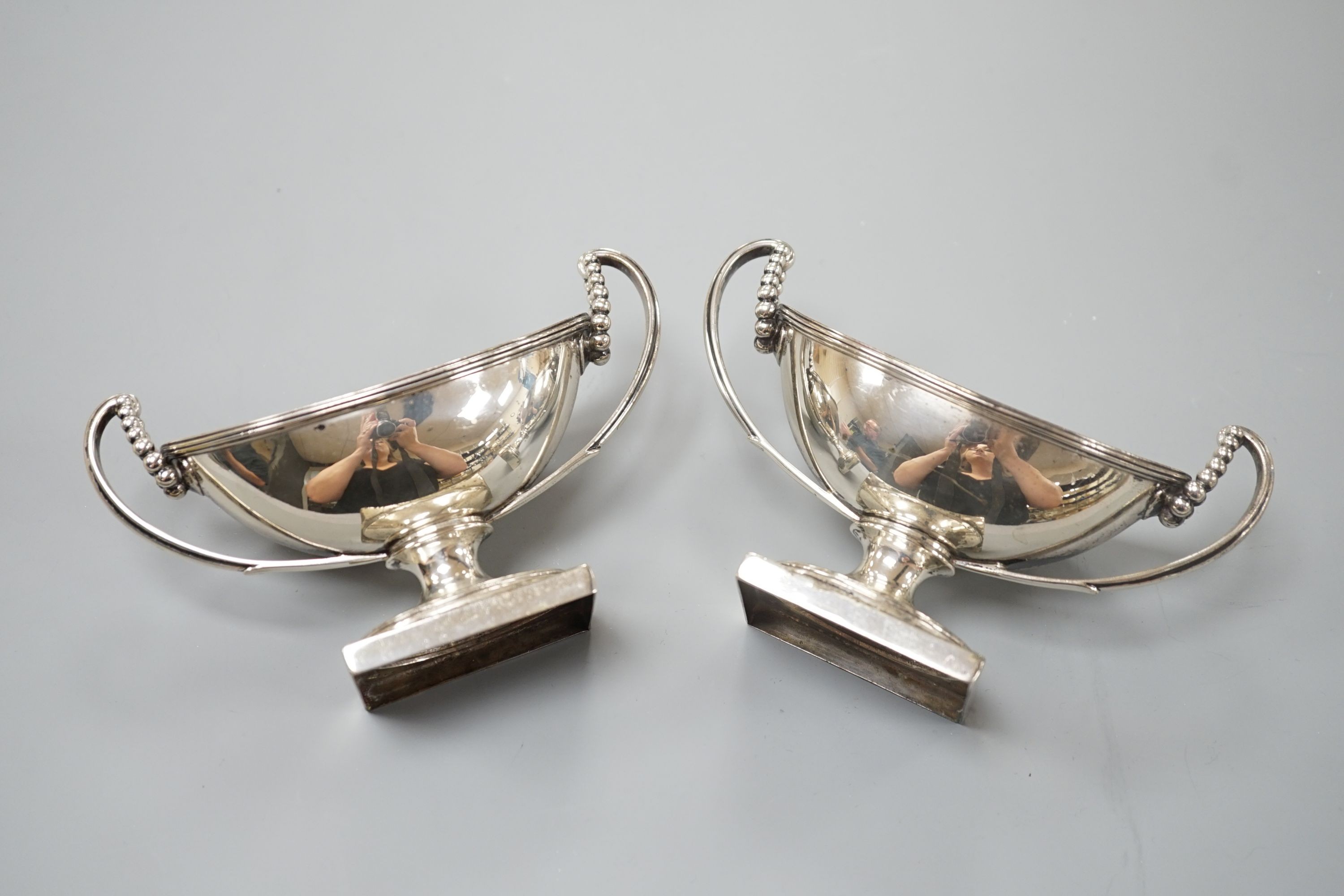 A pair of George III silver boat shaped two handled pedestal salts, Peter Podio, London, 1798, width 31.2cm, 8.5oz.